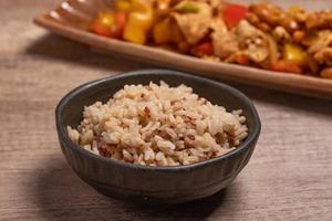 cooked brown rice in a cup on wooden background photo
