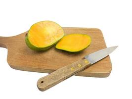 mango is halved with a knife on a wood. so that the inside is visible in orange .isolated on a white background photo