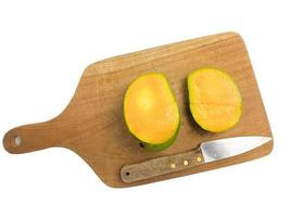 mango is halved with a knife on a wood. so that the inside is visible in orange .isolated on a white background photo