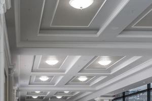 suspended and grid ceiling with halogen spots lamps and drywall construction in empty room in store or house. Stretch ceiling white and complex shape. photo
