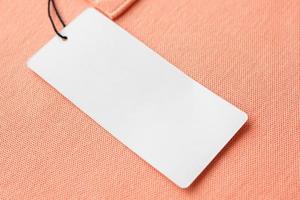 etiqueta de etiqueta de ropa blanca en blanco sobre fondo de textura de tela rosa foto