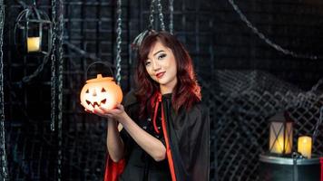 Portrait Teenage beautiful woman wearing witch costume holding pumkin in halloween theme.Emotion happy photo