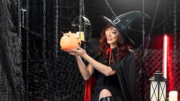 Happy halloween, Beautiful woman wearing witch costume looking lantern pumkin. photo