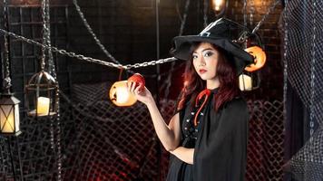 Happy halloween, Beautiful woman wearing witch costume holding apple. photo