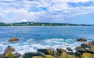 Beautiful surfer waves rocks cliffs at beach Puerto Escondido Mexico. photo