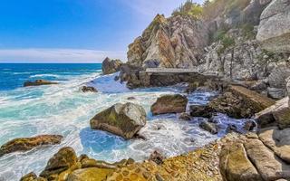 Beautiful surfer waves rocks cliffs at beach Puerto Escondido Mexico. photo