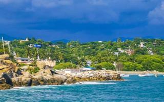 Beautiful surfer waves rocks cliffs at beach Puerto Escondido Mexico. photo