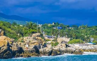 Beautiful surfer waves rocks cliffs at beach Puerto Escondido Mexico. photo