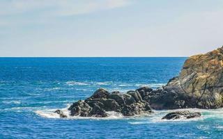 Beautiful surfer waves rocks cliffs at beach Puerto Escondido Mexico. photo