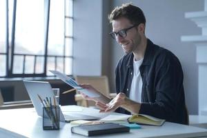 Young German businessman in glasses discussing calculation chart reports with partners online photo