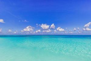 Bright beautiful seascape, sandy beach, clouds reflected in the water, natural minimalistic background and texture, panoramic view banner. Sea ocean ecology nature concept. Blue sky clouds, idyllic photo
