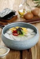 Tteokguk, Korean Sliced Rice Cake Soup, Oval Shaped Rice Cake Cooked in Clear Broth. Traditional Lunar New Year Dish. photo