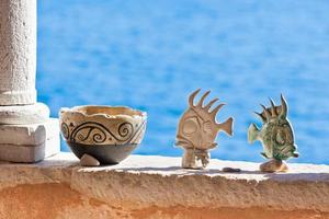 Clay pot and fishes stand on wall photo