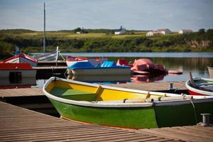 botes flotantes de madera de color con remos en un lago foto