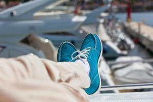 Human legs in pants and bright blue topsiders on yacht photo