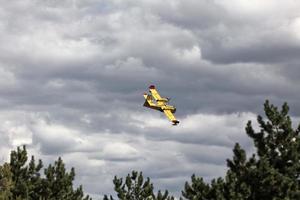 Bright Yellow Firefighter Plane in a Cloudy Sky photo