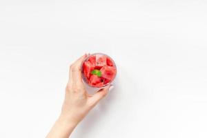 Woman hands with crushed watermelon in glass photo