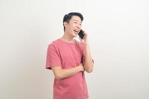 young Asian man using or talking smartphone and mobile phone with happy face photo