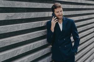 exitoso abogado masculino hace conversaciones de consulta a través de un teléfono inteligente foto