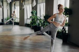 mujer pelirroja delgada atlética durante su entrenamiento de fitness con banda de resistencia de goma foto