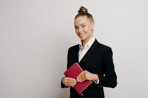 Happy business woman in dark suit posing indoors photo