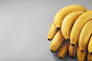 A bunch of fresh yellow bananas on a gray background in the fashionable colors of 2021 photo