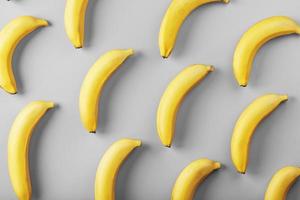 Bright pattern of yellow bananas on a gray background fashionable colors of 2021. photo