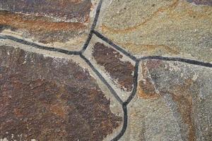 la textura de la pared de piedras de granito de diferentes formas y colores. foto