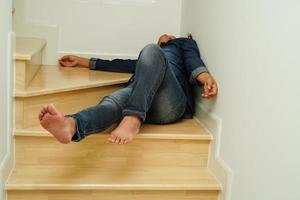 lesiones de mujeres asiáticas por caerse en escaleras de superficies resbaladizas en casa. foto