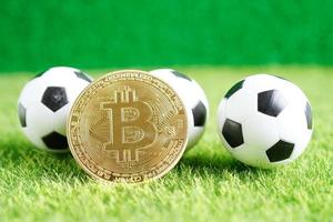 Gold bitcoin with soccer ball or football, cryptocurrency used in online sports betting. photo