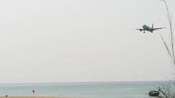 phuket, tailandia 26 de noviembre de 2019 - la aerolínea de bajo costo airasia para pasajeros llega al aeropuerto de phuket. el avión está volando sobre el mar. concepto de turismo y viajes video