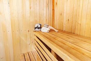 Interior details Finnish sauna steam room with traditional sauna accessories scoop felt hat towel. Traditional old Russian bathhouse SPA Concept. Relax country village bath concept. photo