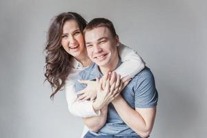 Romantic sexy couple in love having nice time together. Young woman hugging boyfriend, white background photo