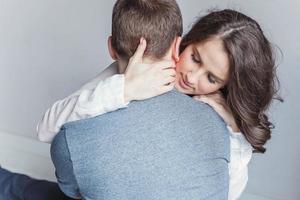 Romantic sexy couple in love having nice time together. Young woman hugging boyfriend, white background photo