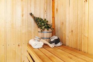 Interior details Finnish sauna steam room with traditional sauna accessories basin birch broom scoop felt hat towel. Traditional old Russian bathhouse SPA Concept. Relax country village bath concept. photo