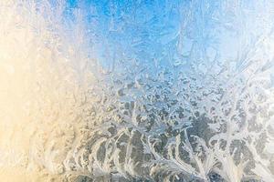 ventana de invierno congelada con textura de patrón de escarcha de hielo brillante. símbolo de maravilla de navidad, fondo abstracto. baja temperatura del extremo norte, nieve de hielo natural sobre vidrio escarchado, clima frío de invierno al aire libre. foto