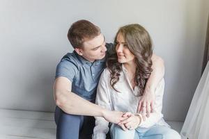 Romantic sexy couple in love having nice time together. Young woman hugging boyfriend, white background photo