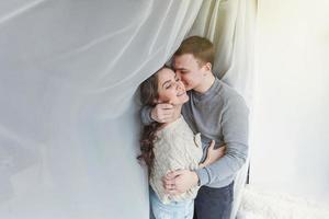 Romantic sexy couple in love having nice time together. Young woman hugging boyfriend, white background photo