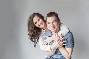 Romantic sexy couple in love having nice time together. Young woman hugging boyfriend, white background photo