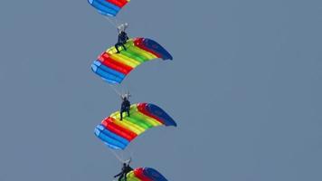 novosibirsk, ryska federationen 28 juli 2019 - fallskärmsjägare aerobatic team med regnbågsfallskärmar. flyguppvisning på mochishe-flygplatsen unnm video