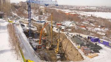 novosibirsk, federação russa, 14 de março de 2021 - vídeo de timelapse de vista superior do canteiro de obras no início da construção de um novo projeto habitacional. trabalhadores e máquinas se movem rápido e ocupado no desenvolvimento video