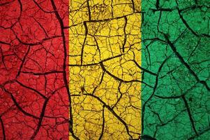 Dry soil pattern on the flag of Guinea. Country with drought concept. Water problem. Dry cracked earth country. photo