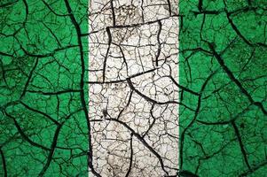 Dry soil pattern on the flag of Nigeria. Country with drought concept. Water problem. Dry cracked earth country. photo