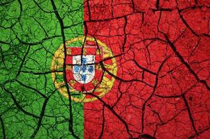 Dry soil pattern on the flag of Portugal. Country with drought concept. Water problem. Dry cracked earth country. photo