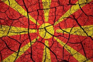 patrón de suelo seco en la bandera de macedonia. país con concepto de sequía. problema del agua país de tierra seca y agrietada. foto