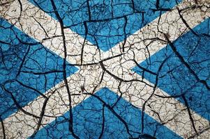 Dry soil pattern on the flag of Scotland. Country with drought concept. Water problem. Dry cracked earth country. photo