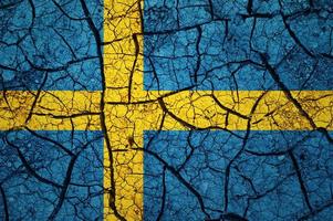 Dry soil pattern on the flag of Sweden. Country with drought concept. Water problem. Dry cracked earth country. photo