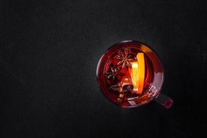 Christmas mulled red wine with spices and fruits on a concrete table photo
