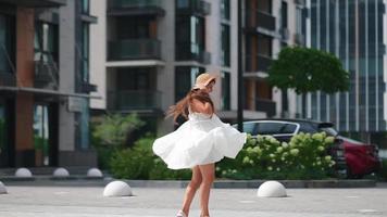 femme vêtue d'une robe blanche fluide marchant dans la rue video