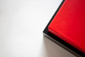 dos cajas rojas y negras en una pila sobre un fondo blanco. lugar para tu texto foto
